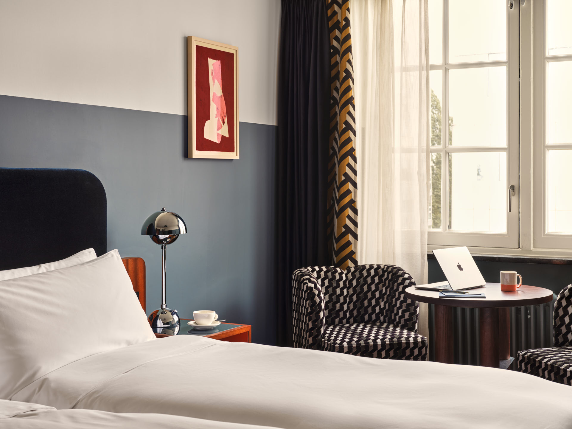 One twin bed beside window with coffee table and armchair between