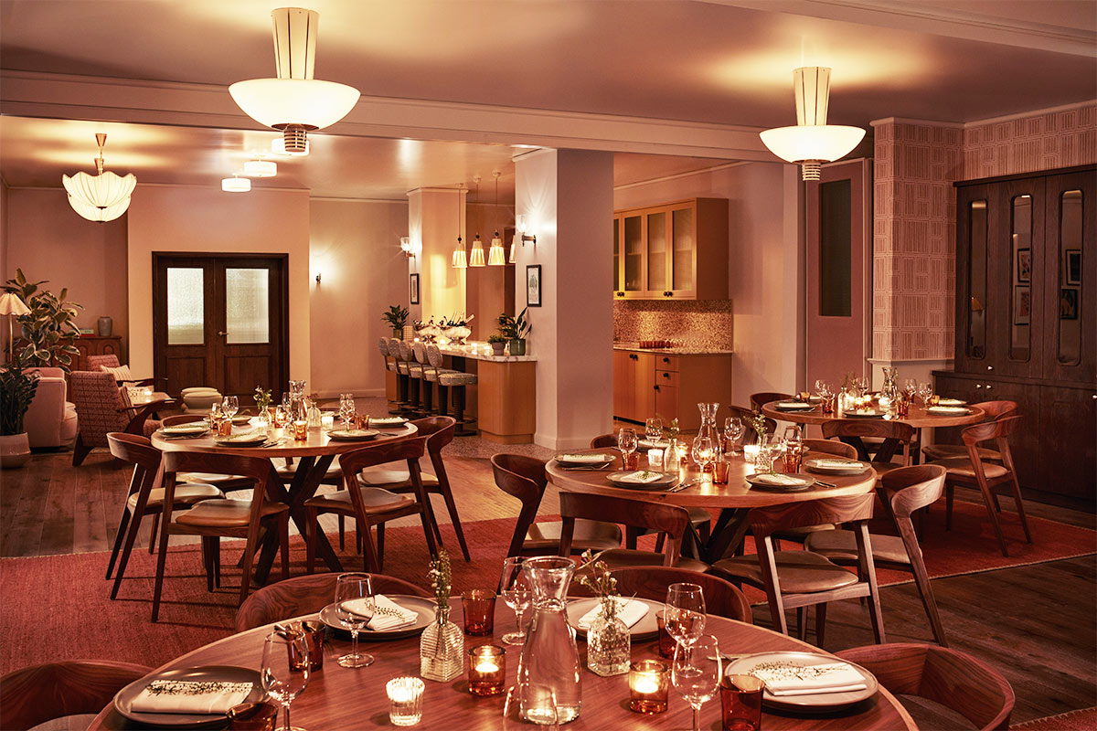 An open-plan meeting or dining space with warm light available to hire at The Hoxton, Shepherd's Bush hotel.