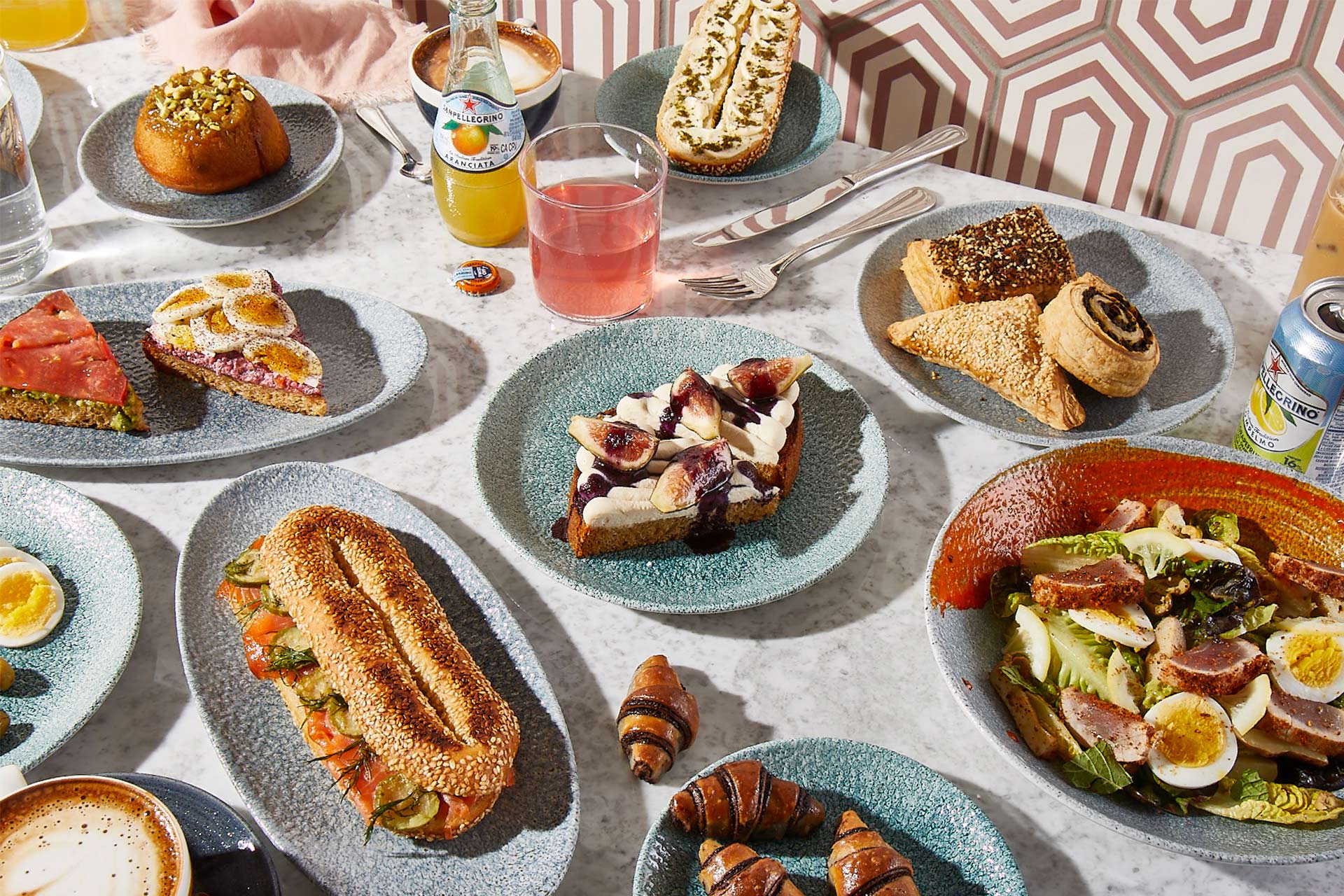 Array of food and drink from K'Far including salads, pastries and sandwiches.