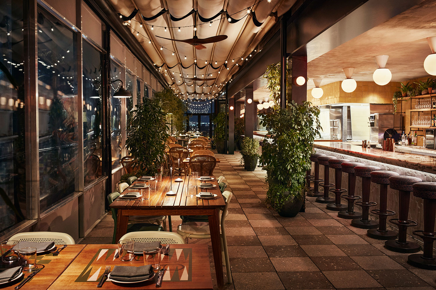 Interior of Laser Wolf with evening lighting and potted plants.
