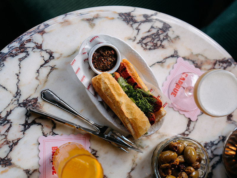 Drinks and snacks served on a marble table at the Barbue bar