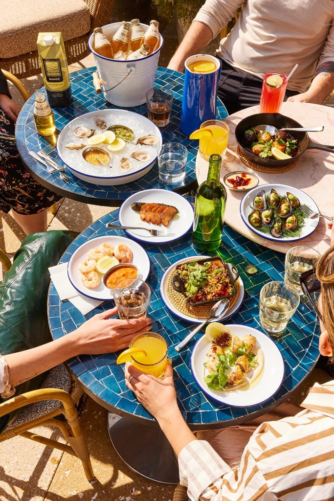 Round blue tables moved together to hold a selection of menu items from Jaffa.
