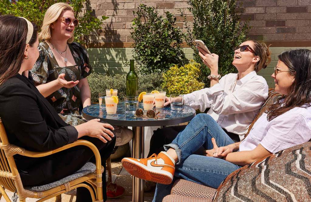 Four female diners with cocktails enjoy an outdoor dining experience at Jaffa.