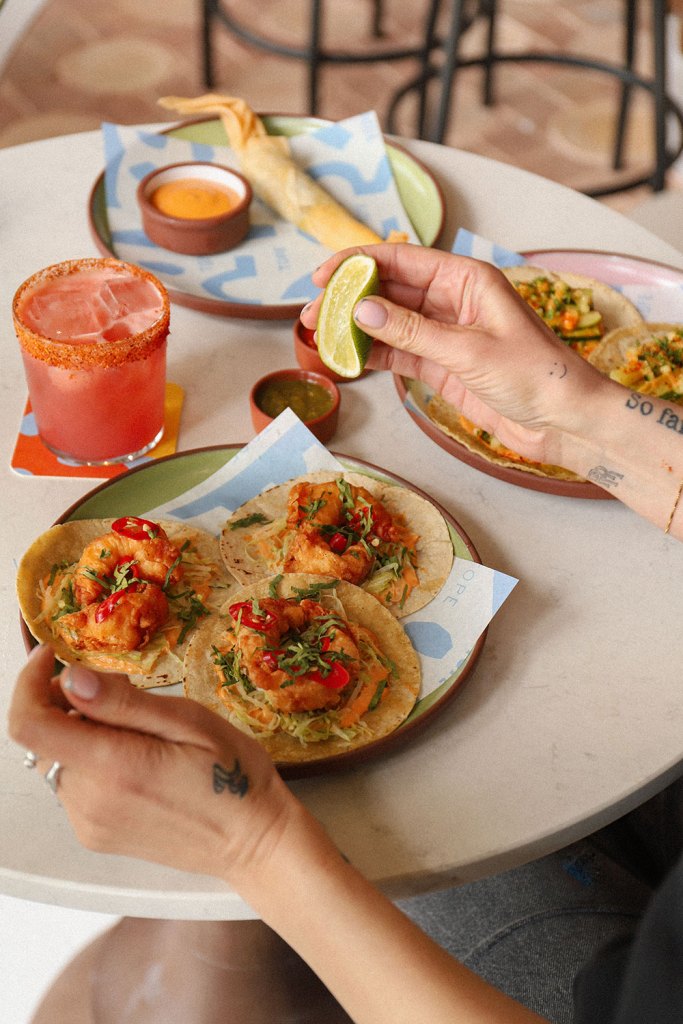 Lime squeezed over a plate of spicy prawn tacos.