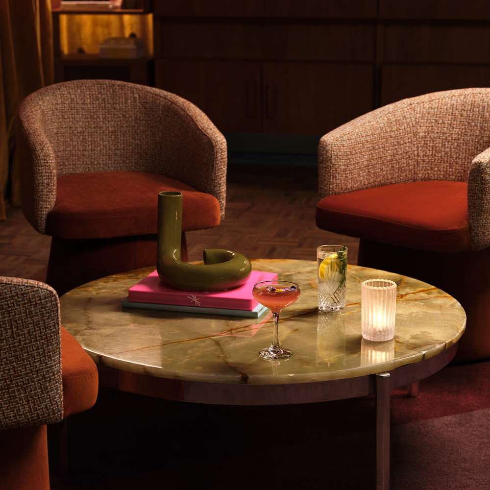 Armchairs arranged around cocktails on a round table