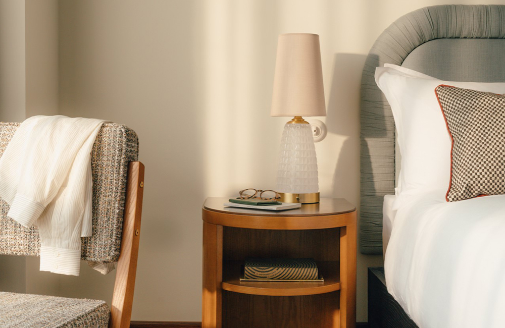 Low view of part of the bed, bedside table and chair.
