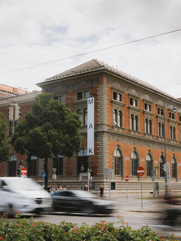 Exterior of the M.A.K building with traffic in the foreground