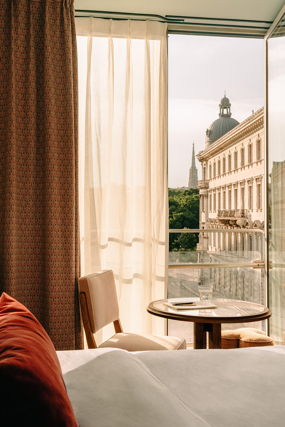 View of the city of Veinna through the half-curtained window in a hotel bedroom