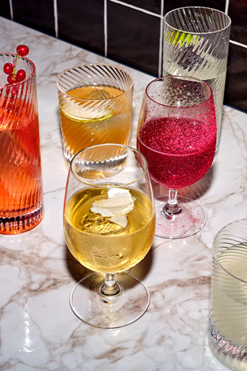 A ray of colourful cocktails on a marble bench.