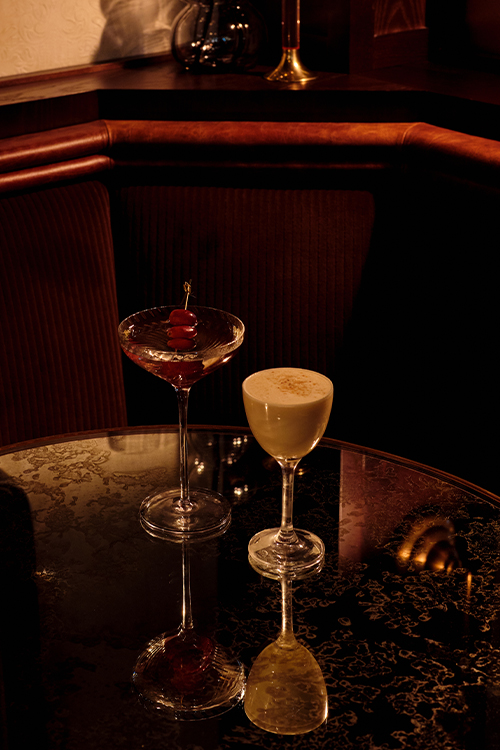 Two cocktails on mirror table in one of the bar booth.