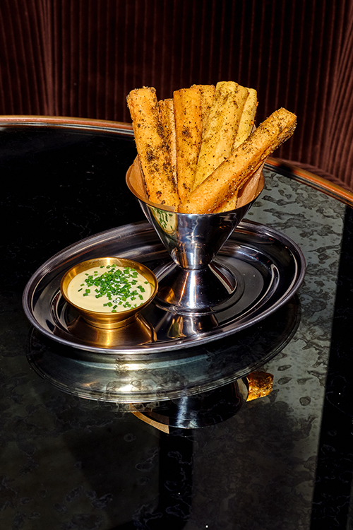 Potato chips with dip served on a silver tray.