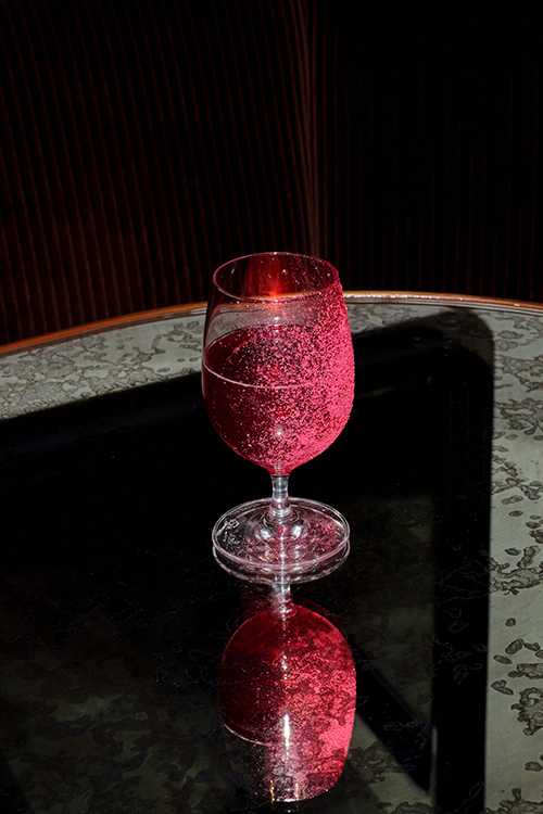 Bright red cocktail pink on mirror table.