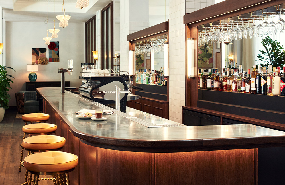 The lobby bar showcases a large countertop, bar stool and loads of natural light.