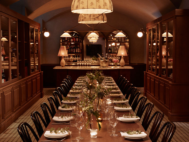 Hoxton Florence cellar event space, featuring a long table at the center and wine cupboards lining the walls.
