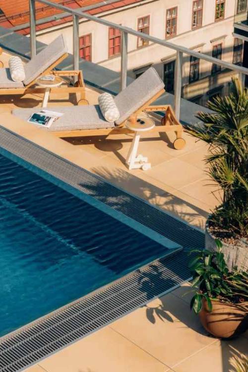Above view of pool and sun loungers on a rooftop