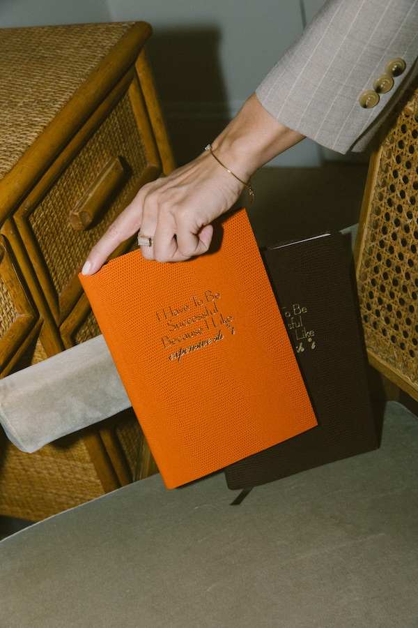 Photos by Nic Ford.Hand holding a bright orange book. - The Localist, Hoxton Hotels.