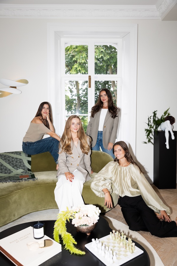 Group photo of 4 female around a green velvet sofa and several different ornaments on a black coffee table.- The Localist, Hoxton Hotels.