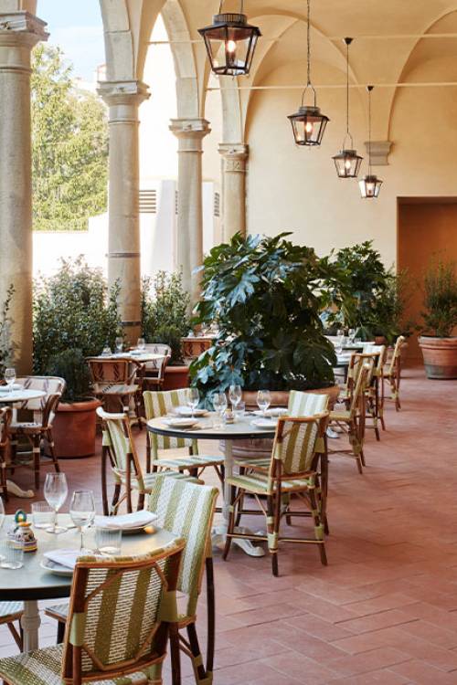 Alassio open terrace with a courtyard view, abundant natural light, shaded areas, and lush greenery.